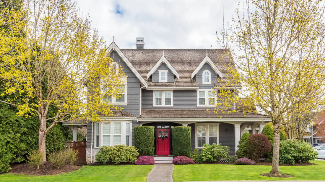 Envy-inducing house with gray siding, brown shingle roof, white trim, red door